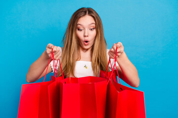 Photo of nice young girl look open shop bags wear top isolated on blue color background