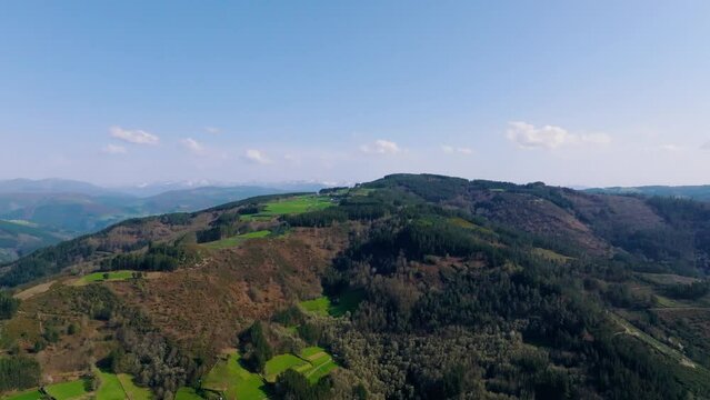 Aerial footage of a scenic lush woods on green rolling hills in A Fonsagrada, Lugo, Galicia, Spain