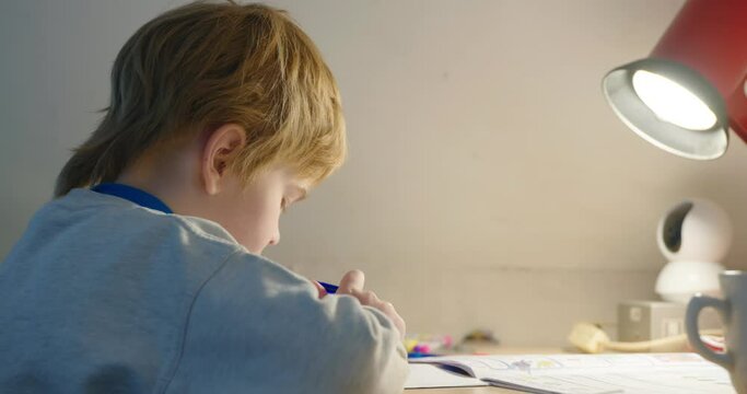 Kid Boy Study at Home. Schoolboy Doing Homework Sitting at Desk Table. 4K 10-bit