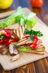 fried toast with chicken, salad, greens on a wooden table
