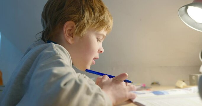 Kid Boy Study at Home. Schoolboy Doing Homework Sitting at Desk Table. 4K 10-bit