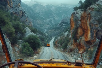 A trucker's view from the cab as they navigate a winding mountain road, with steep cliffs and...