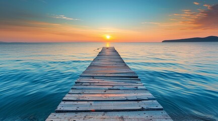 Beautiful sunrise over the sea with a wooden pier, blue sky and calm water in summer time