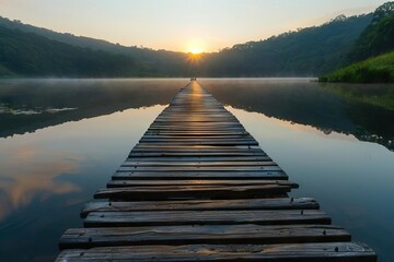 Long wooden pier stretching into a serene lake at sunrise, providing a peaceful and reflective...