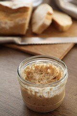 Sourdough starter in glass jar on wooden table