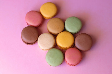 Colorful macarons on pink background. Selective focus.