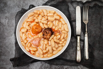 fabada asturiana, a typical spanish bean stew in white bowl