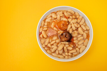 fabada asturiana, a typical spanish bean stew in white bowl