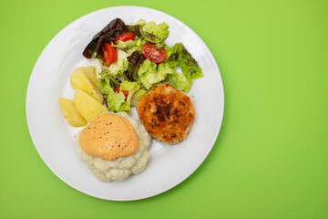 Fried chicken meatballs with boiled vegetables on white plate