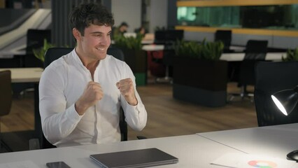 Caucasian happy smiling successful productive achievement businessman accomplished online task computer work end close laptop table lamp light off good result business man take phone leaving office