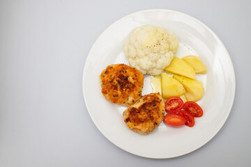 Fried chicken meatballs with boiled vegetables on white plate