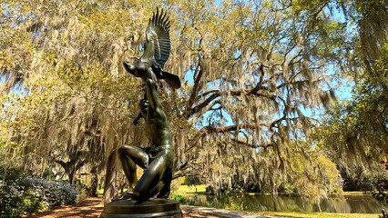 Statue of native American with bird against live oak tree with spanish moss