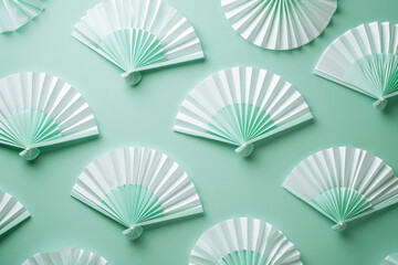 Decorative green and white paper fans arranged on a green wall with a blue background
