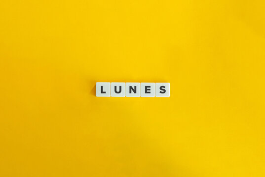 Word LUNES. Monday in Spanish. Text on Block Letter Tiles on Yellow Background. Minimalist Aesthetics.