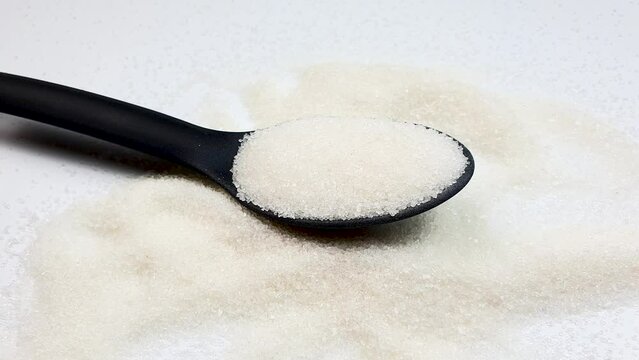 Spoonful of sugar. Sugar, additive, ingredient on white background.