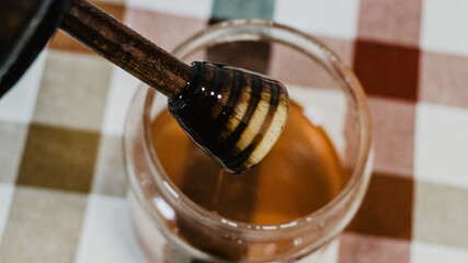 Honey pot with wooden lid on the table