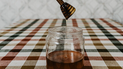 Honey pot with wooden lid on the table