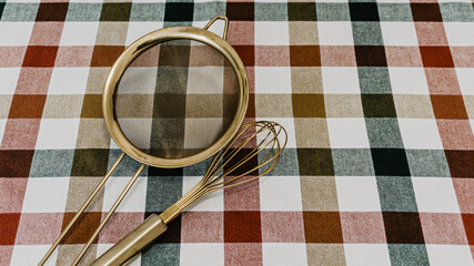 Golden colander and kitchen rod on the table