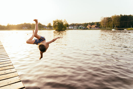 young boy diving into water. Active child splashes inside lake. Kid enjoying summer vacations
