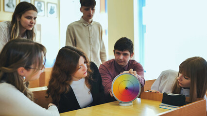 Students in physics class spin Newton's multicolored disk.