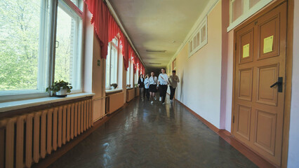 The students are running down the hallway of the school.