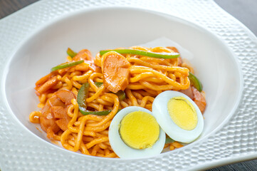 A plate of spaghetti with sausage and green peppers.