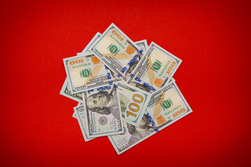 a pile of old and new dollars on a red background.