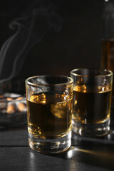 Alcohol addiction. Whiskey in glasses on black wooden table