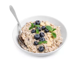 Fotobehang Tasty oatmeal with blueberries, mint and almond flakes in bowl isolated on white © New Africa