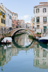 Charming Venetian Canal with a Small Bridge: Picturesque View of Ancient Italian Buildings...