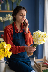 Hispanic woman taking order, florist working from home, female florist taking client order to arrange flower bouquet delivery. Flower design