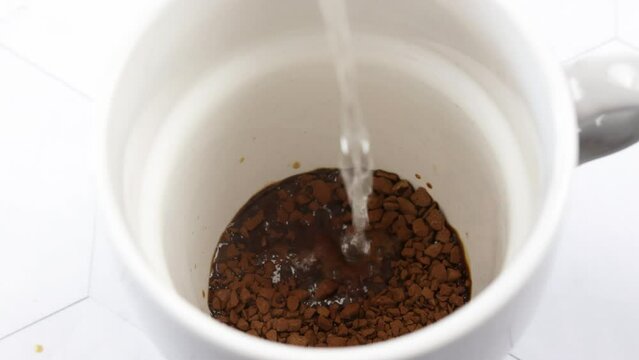 eau vers&eacute;e dans une tasse de caf&eacute; soluble.