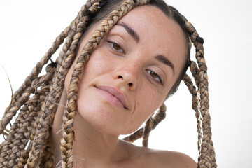 A portrait of a woman with dreadlocks half-smiling