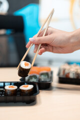 Sushi delivery. Set of rolls in a disposable box on a black background. Top view