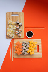 Sushi delivery. Set of rolls in a disposable box on a black background. Top view