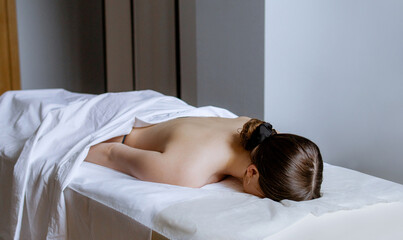 Woman enjoying massage of her back, body at spa salon. Professional masseur making spa therapy....