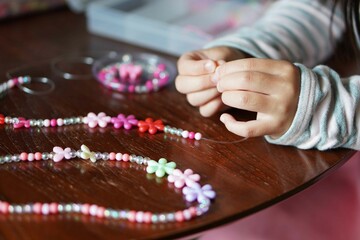 小学一年生の女の子がビーズ遊びをしている様子