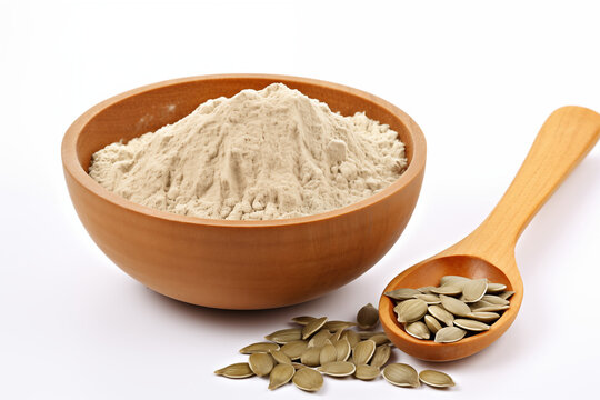a wooden bowl of Pumpkin Seed flour and 1 spoon of Pumpkin Seed on a white background