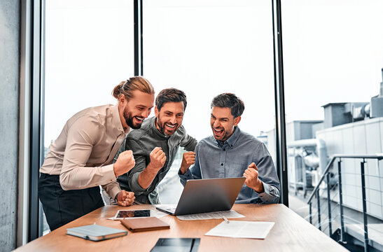 Confident successful business partners celebrate growth in business. Professionals at work in the office express the joy of victory and success in business.Closing a deal,achieving success.