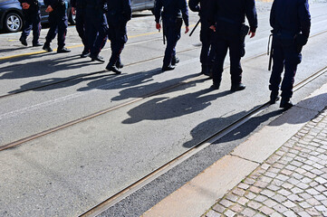 policemen lined up marching during a protest against government choices about social issues