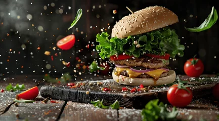 Fotobehang Hamburger volant avec éclaboussures et ingrédients, sur une table en bois, publicité alimentaire. © David Giraud