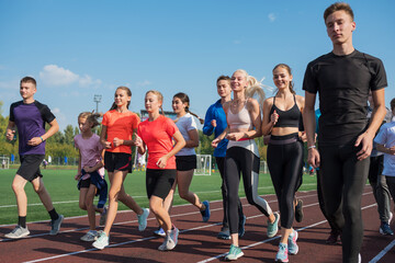 Group of young athletes training at the stadium