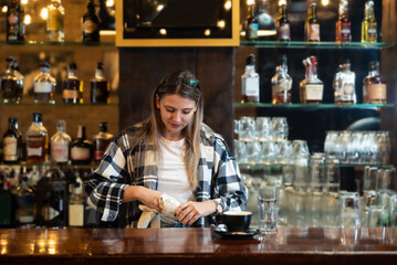Waitress standing in bar and wiping and polishing beer glass. Bartender woman working in bar...