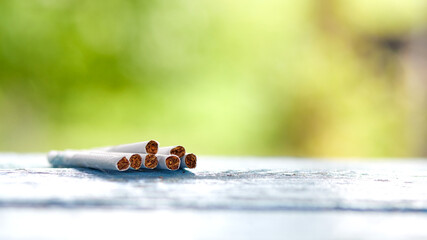 Tobacco in the cigarette, lying on a wooden table. Closeup photo with selective focus