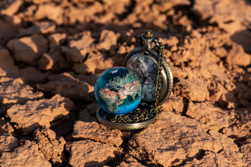 Miniature glass globe on heat-cracked clay in the desert