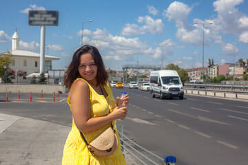 the plus size woman in yellow dress standing against the road