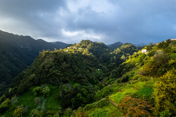 Fototapeta na wymiar Madeira Island landscape, small village on hills and green lush forest. Aerial drone view. Portugal travel.