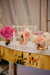 Table decoration from pink and  white roses and  candle sticks on the table at wedding  reception.