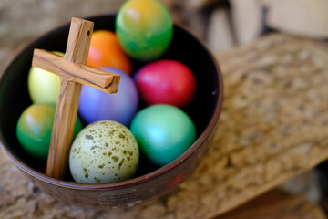 Happy Easter. Easter colored eggs with a wooden cross.  The Resurrection of Christ is the most ancient and Christian holiday.  Closeup of multicolored dyed eggs for the traditional Easter celebration.