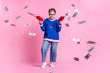 Full body portrait of nice aged lady shoot money bills wear blue sweater isolated on pink color...